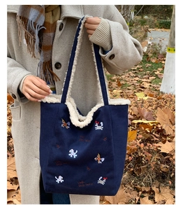 Dettaglio della borsa tote blu navy con fodera in sherpa bianco e ricamo a cavallo colorato
