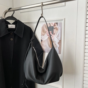 Detail of black hobo bag with lychee texture faux leather and silver metal zipper