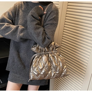 Detail of silver quilted bucket bag featuring drawstring closure and metallic finish