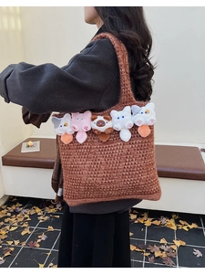 Detail of hollow knit tote bag with five cute 3D plush cat charms on a shoulder strap