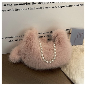 Détail du sac croissant en peluche rose avec poignée décorative en perles