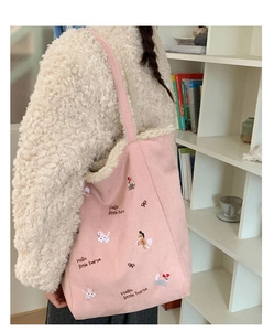 Dettaglio della borsa tote in tela rosa con bordo in shearling e ricamo