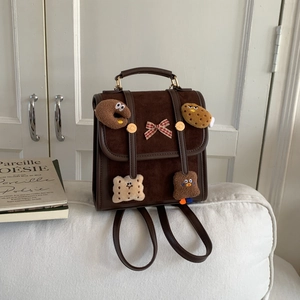 Detail of vintage brown mini backpack with plaid bow and cute food plush patches