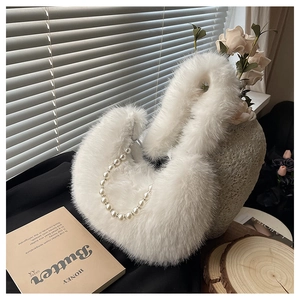 Détail d'un sac à main blanc en fausse fourrure avec anse en perles élégantes