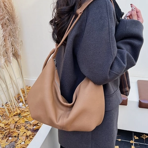 Close-up of camel hobo bag in lychee pattern leather styled with an autumn coat