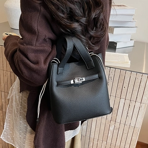 Detailed close-up of black lychee grain leather bucket bag with silver metal swivel lock