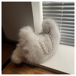 Détail d'un sac à main en fausse fourrure blanche avec chaîne en perles et anneau argenté