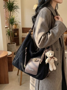 Large black suede tote bag with brown leather trim and cute beige bear pendant