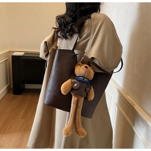 Detailansicht der großen dunkelbraunen Tragetasche mit süßem Teddybär-Anhänger