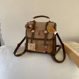 Detail of vintage patchwork backpack with cute cartoon food plushies and a plaid bow