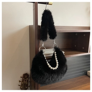 Détail du sac croissant en fausse fourrure noire avec chaîne perlée et peluche