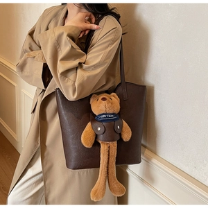 Nahaufnahme der dunkelbraunen Leder-Shopper-Tasche mit süßem Teddybär-Anhänger