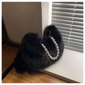 Détail d'un sac à main en fausse fourrure noire avec poignée en perles blanches chic