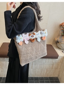 Detail of five cute plush cat dolls on a brown hollow-out knitted crochet tote bag
