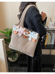 Close-up of knit hollow tote bag featuring cute plush cat dolls in a cozy home setting