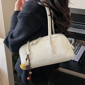 Dettaglio borsa bowling bianco crema in pelle martellata con ciondoli decorativi