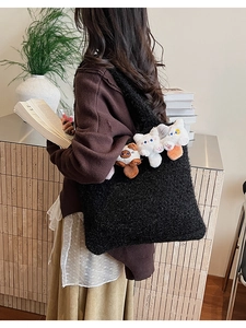 Detail of black faux fur tote bag featuring cute plush animal charms and soft texture