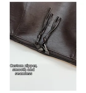 Dettaglio della cerniera in metallo personalizzata con nappine in pelle su borsa marrone