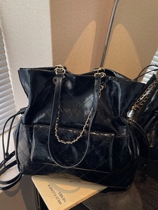 Fashionable black quilted leather tote bag with chain strap and glossy wrinkled finish