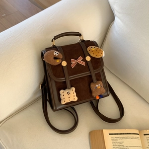 Close-up of retro brown backpack with plush biscuit patches on a soft fabric sofa