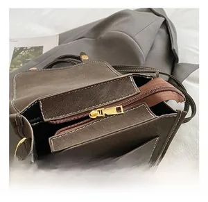 Close-up of golden zipper and hardware details on dark brown frosted leather backpack