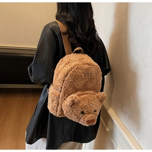 Détail du sac à dos ours en peluche marron montrant son visage mignon et ses bretelles