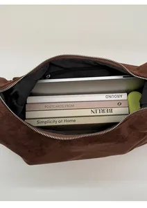 Interior view showing large capacity of brown suede tote bag with laptop and books