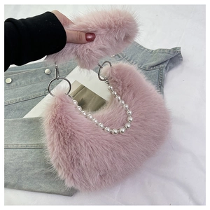 Détail d'un sac à main rose en peluche avec chaîne perlée et texture fausse fourrure