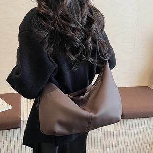 Detailed back view of a large brown hobo bag showing its soft lychee texture and slouchy shape