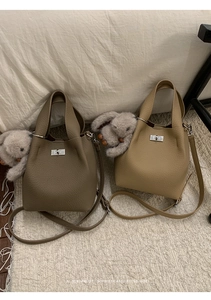 Detailed view of luxury leather bucket bags with silver square twist lock and grainy texture