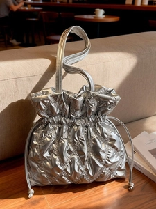 Quilted silver drawstring bucket bag with a stylish metallic finish for winter fashion