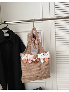Close-up of brown crochet tote bag with five cute colorful cat plush dolls along the edge