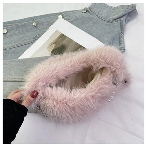 Gros plan détaillé du sac à main en fausse fourrure rose avec perles blanches et chaîne
