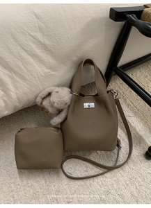 Detailed view of bucket bag featuring lychee grain leather and silver twist lock