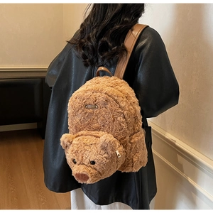 Détail du sac à dos ours en peluche avec fourrure marron douce et plaque en métal