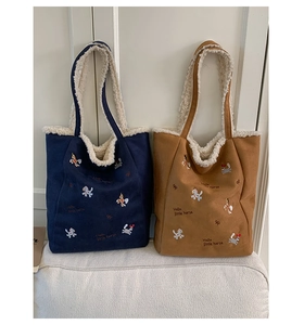 Dettaglio delle borse a secchiello in peluche blu e marrone con fodera in lana e ricami