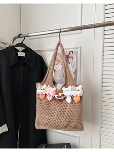 Detail of hollow knit tote bag with five cute plush cat heads in a lifestyle setting