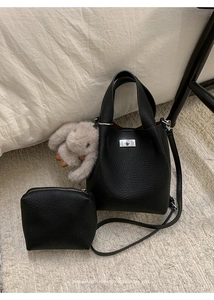 Detail of black pebbled leather bucket bag with silver clasp, pouch and rabbit charm