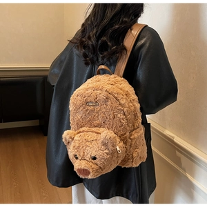 Détail du sac à dos ours en peluche marron avec plaque Lovely Bear et bretelles en cuir