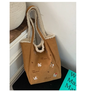 Dettaglio della borsa vintage con bordo in pile e ricamo di un piccolo cavallo