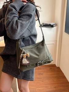 Olive green retro tote bag with buckle detail and heart pendant in a lifestyle setting