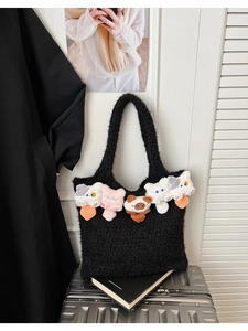 Close-up of black knit tote bag featuring five colorful plush cartoon cat pendants