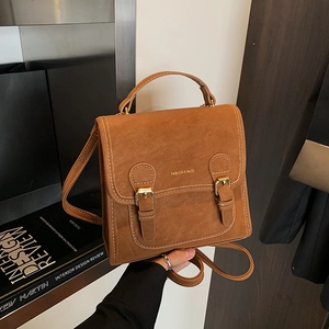 Close-up of vintage brown frosted texture bag with metal buckles and fashion print