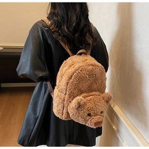 Détail du dos d'un sac à dos en peluche ours brun avec des sangles en cuir réglables