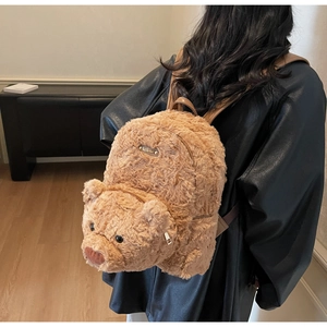 Détail de la plaque en métal Lucky Bear et texture pelucheuse du sac à dos marron