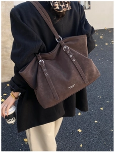 Détail du grand sac cabas en daim marron avec boucles en métal et logo gravé