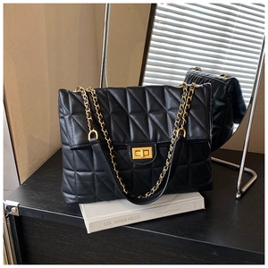 Détail du sac à bandoulière matelassé noir avec chaîne dorée et fermoir rotatif chic