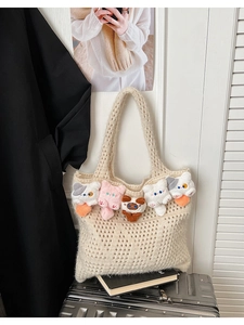 Detail of crochet knit tote bag with colorful plush cat charms and geometric hollow patterns