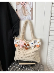Detail view of beige crochet tote bag featuring cute plush cat heads along the opening