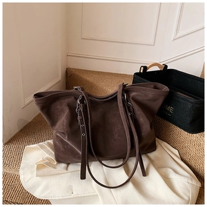 Détail de la texture du grand sac cabas vintage marron et des boucles métalliques
